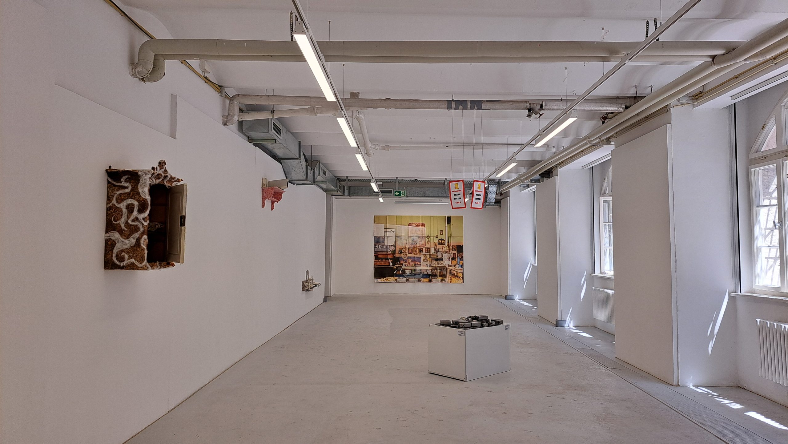 Ausstellungsansicht mit positionierten Arbeiten im großen Raum.